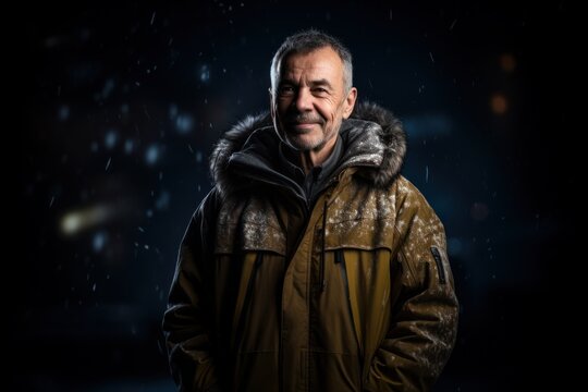 Senior man with winter clothes freezing in the snow on black background.