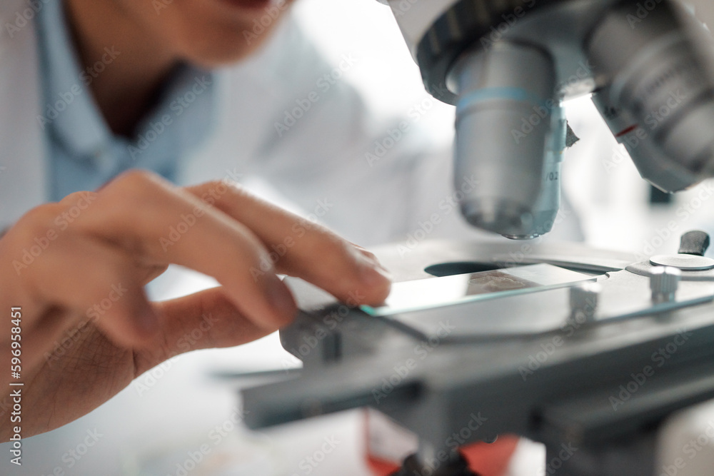 Poster i wonder what this holds. shot of a male lab tech positioning a slide under a microscope.