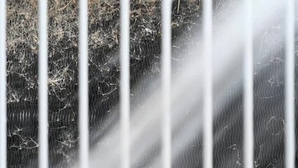 Slow Motion , no sound video of washing and cleaning the heat exchanger coils of an air conditioner outside. 