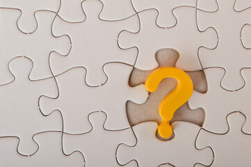 The image of a yellow question mark on a jigsaw puzzle background conveys the ideas of problem-solving, confusion, seeking solutions, and counseling.