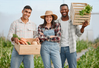 Well bring the freshest to the table for you. Portrait of a group of people holding crates of fresh...