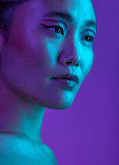 Barely grinning. Cropped shot of an attractive young woman posing in studio against a purple background.