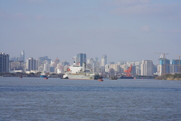 Fototapeta premium The modern city view along the side of the river in the sunny day