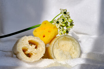 Scrub, loofah washcloth and organic sea sponge on the towel.