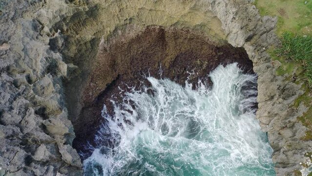 Aerial view of the waves hitting the rocks