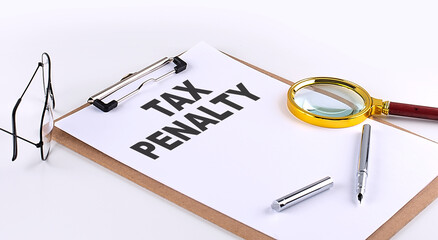 TAX PENALTY text on clipboard on white background, business concept