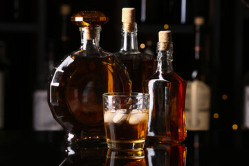 Bottles and glass of cold rum on table in bar