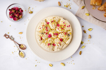 Plate of tasty Tahini halva with pistachios on light background