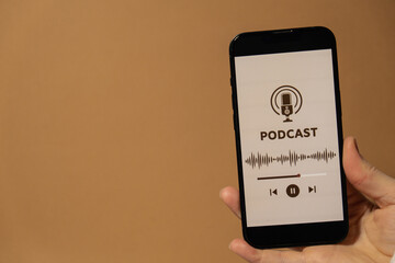 Unrecognizable woman holding mobile phone Podcast listening website page app application with wireless headphones. Audio healing, sound therapy wellness rituals, positive mental health habits