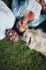 Everyone knows about the circle of life. Shot of a young couple lying on the grass with their dog in their garden at home.