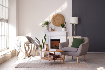 Interior of bright living room with armchairs, coffee table and fireplace