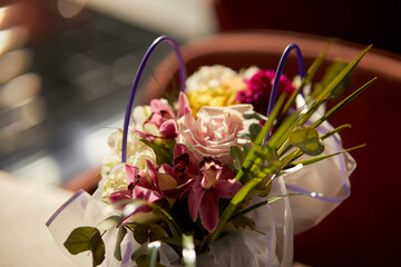 festive bouquet of flowers on the table. Glass vase with a bouquet of beautiful flowers on the table in the room. Place for text. Beautiful bouquet in a festive package on the table