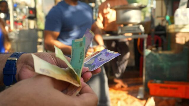 Close-up of male hands counting a stack of Indian banknotes, a businessman is counting cash, selective focus