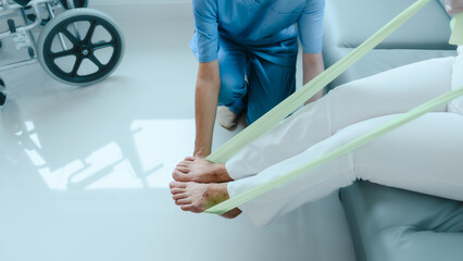 Asian Chinese female physiotherapist caregiver helping elderly woman exercise for recovery, prevention of osteoarthritis and osteoporosis.