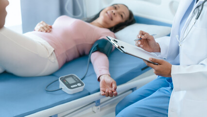 Obraz premium Asian Chinese female physiotherapist caregiver helping elderly woman exercise for recovery, prevention of osteoarthritis and osteoporosis.