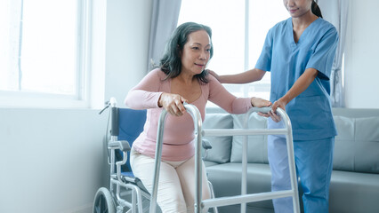 Obraz premium Asian Chinese female physiotherapist caregiver helping elderly woman exercise for recovery, prevention of osteoarthritis and osteoporosis.