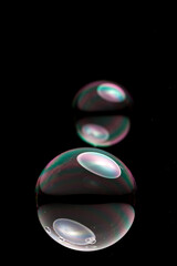 wonderfully shimmering soap bubbles floating in the air in front of a black background