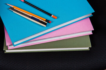 A stack of notebooks with a blue and green cover that says'school supplies'on it