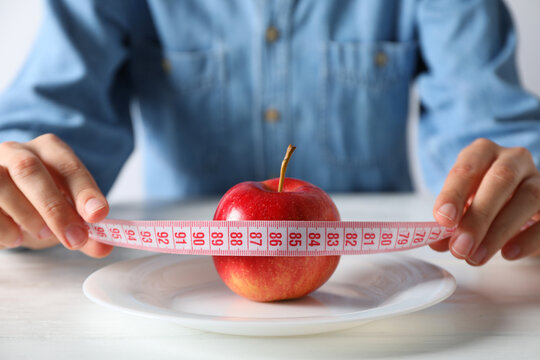 Concept Of Weight Loss And Healthy Nutrition With Apple And Measuring Tape