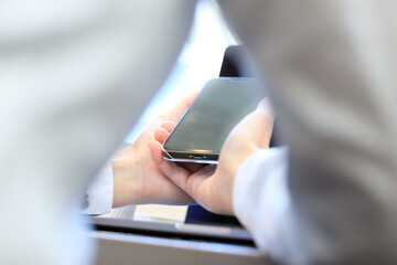 ノートパソコンとスマートフォンを使用している女性　ビジネス