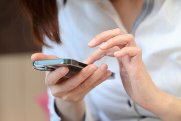 スマートホンを見ている女性　ビジネス　室内