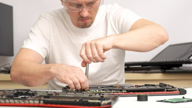 Laptop repair, computer service. Man repairing laptop