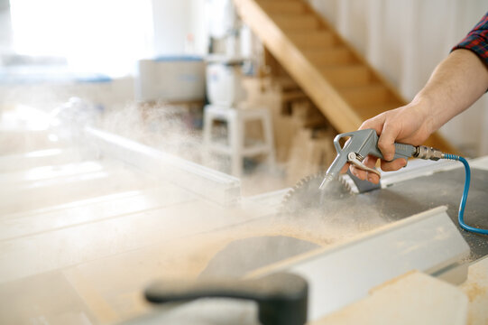Closeup view on carpenter hands washing off sawdust from wood plank