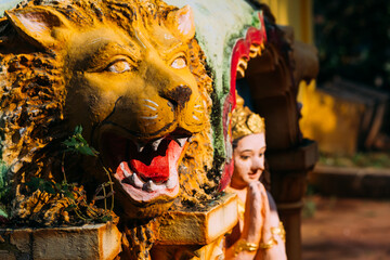 Decorative statue of a yellow lion with an open mouth adorns a Hindu temple in India, Arambol, Goa....