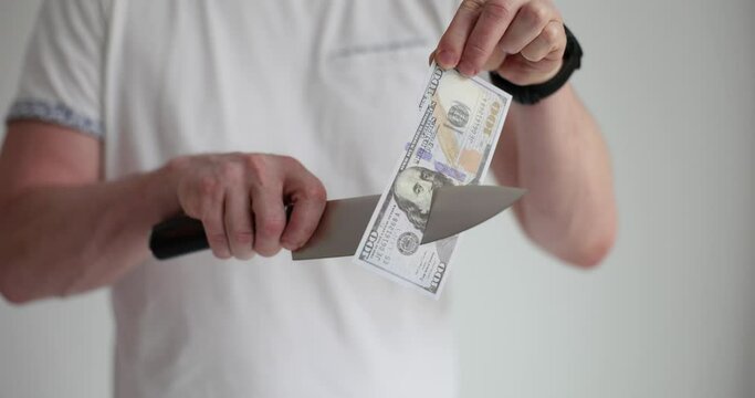 Man cutting dollar bill with sharp knife closeup 4k movie slow motion. Bankruptcy and financial economic crisis concept