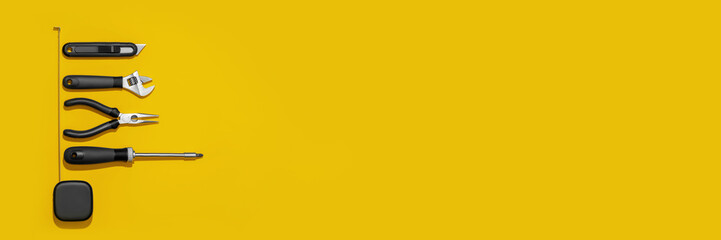Flat lay composition with set of home repair tools on bright yellow background. Top view pattern with copy space. Web banner.