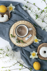 A cup of warm, warming aromatic tea, coffee, flowers nearby