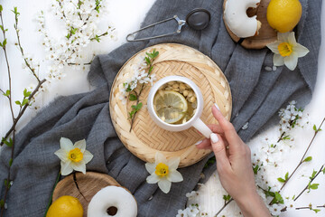 A cup of warm, warming aromatic tea, coffee, flowers nearby