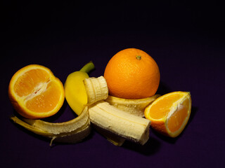 Still life with oranges and bananas on a dark background
