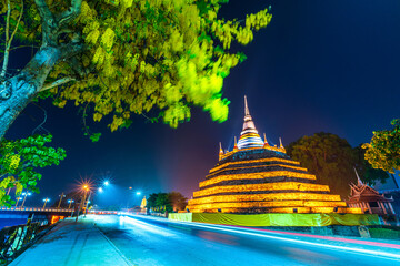 Beautiful The lights on the Road with Yellow flowers Cassia Fistula at Park in Phra Chedi Luang in Temple (Wat Ratchaburana) is a Buddhist temple in Phitsanulok,Thailand at Natural Twilight