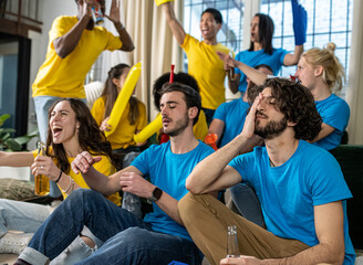 Fans of two different teams share the same match, the yellow team rejoices for the victory, the blue team is disappointed by the defeat