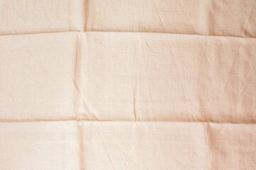 Textured natural background for design. Beige linen fabrics with folded stripes. Top view