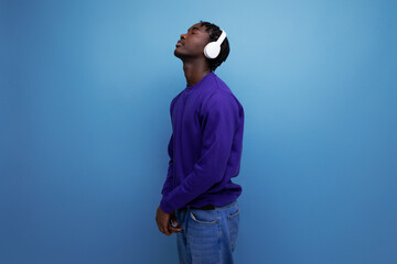 american young man with dreadlocks dancing to music with headphones