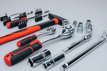 Fototapeta premium A set of working tools, a hammer, a screwdriver, sockets for an answer on a gray concrete background. Front view