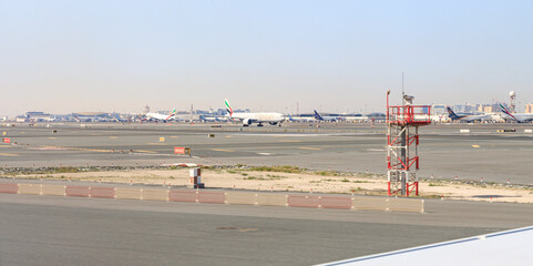 View from the window of a Flydubai aircraft moving along the runway to the standing planes of world airlines and the airport building at Dubai airport
