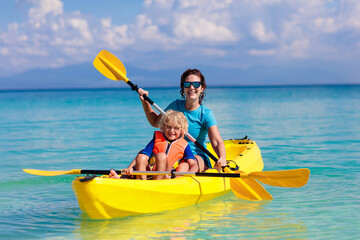 Kids kayaking in ocean. Family in kayak in tropical sea - obrazy, fototapety, plakaty