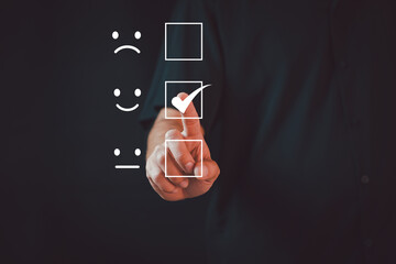 Customer service and Satisfaction concept ,Business people are touching the virtual screen on the happy Smiley face icon to give satisfaction in service. rating very impressed.