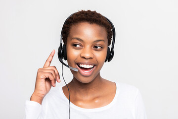 Beautiful successful call centre operator afro american dark skinned woman over white background in studio isolated working sopporting people customers receiving call from clinets.