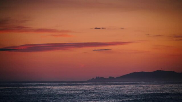 Red orange sky after sunset over sea. Nature, coastal landscape. Capi Corb, Mediterranean coast of Spain.