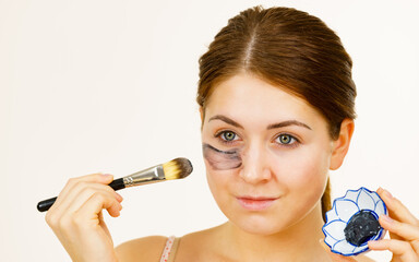 Woman being apply black carbo mask to face