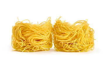 Raw tagliatelle pasta, close-up, isolated on white background.