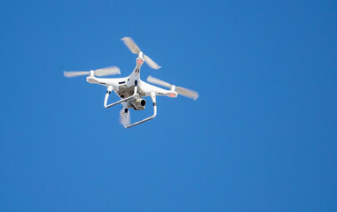 Drone with digital camera flying in the blue sky, closeup of photo