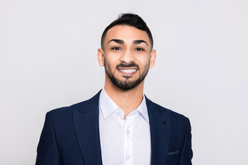 Portrait of happy delighted turkish man in studio isolated over grey background looking at camera smiling with white teeth buisneesman young successful guy.
