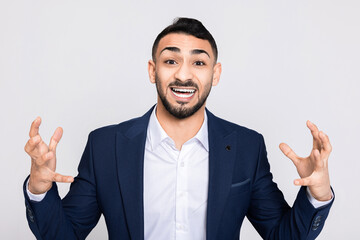 Delighted cheerful shocked man in buisness smart suit and white shirt with a big smile on face looking at camera.