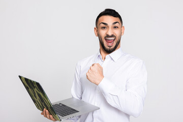 Happy delighted buisnessman in white shirt holding laptop in hands having susscessfull