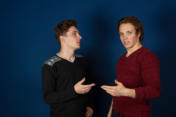 Two young attractive students are posing in the studio. Happy men.	